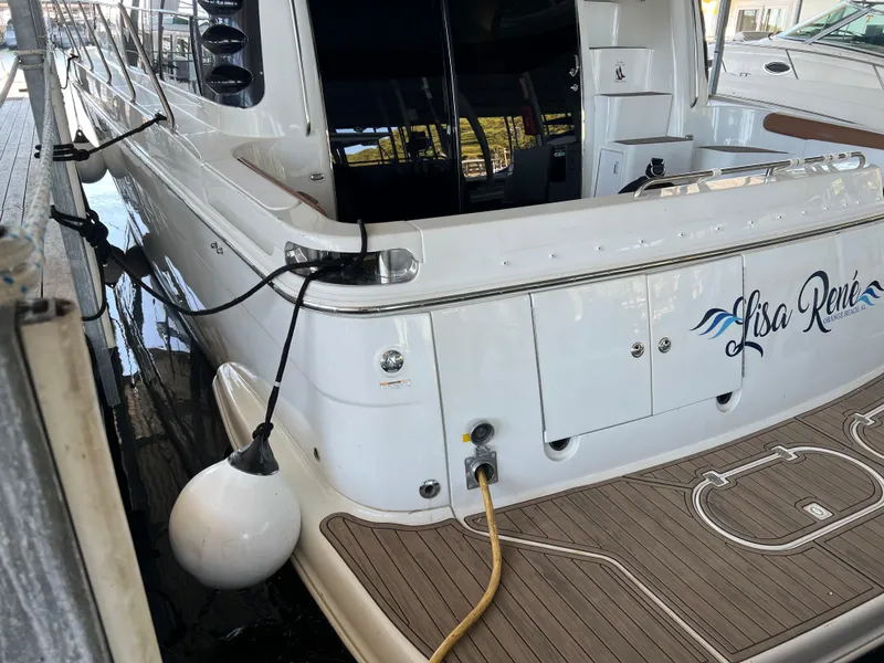 Slide: The Image of 2001 Carver 450 Voyager Pilothouse yacht docked, rear view with deck and name visible. - 9