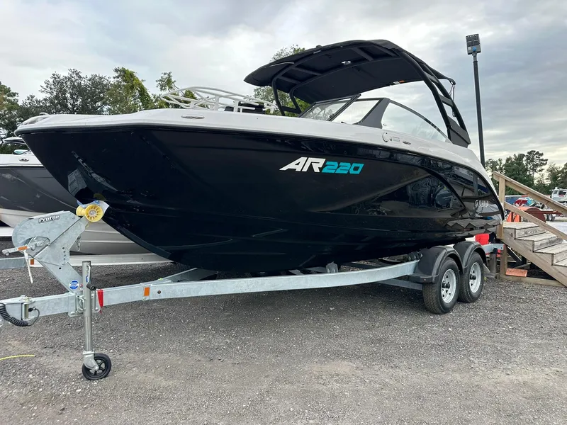 The Image of 2025 Yamaha AR220 boat on trailer, sleek black design, parked outdoors. - 0