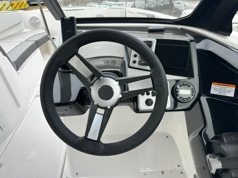 Slide: The Image of 2025 Yamaha AR220 boat steering wheel and dashboard controls. - 17
