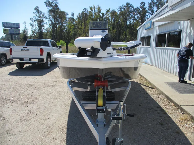 Slide: The Image of 2025 Avid 21 FSX boat on trailer, parked near a building and a GMC truck. - 2