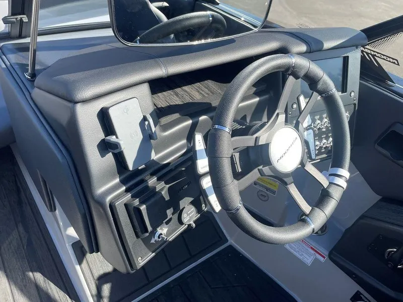 Slide: The Image of 2025 Moomba Mondo boat dashboard with steering wheel and control panel. - 18