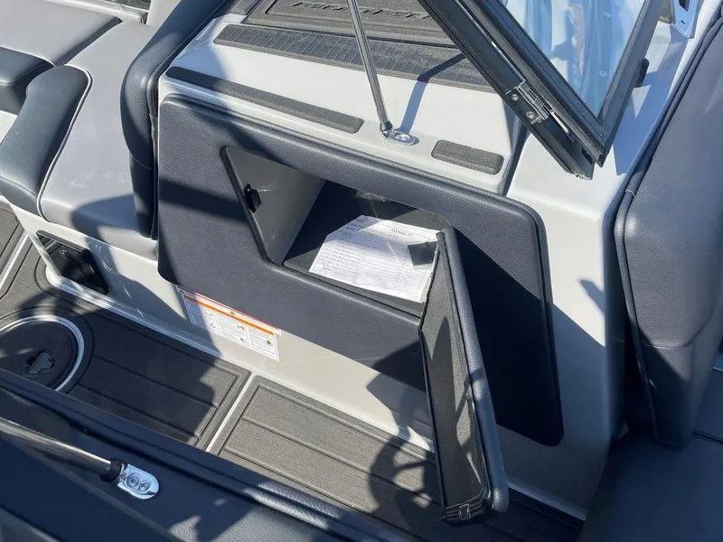 Slide: The Image of 2025 Moomba Mondo boat interior with open glove compartment and visible document. - 19