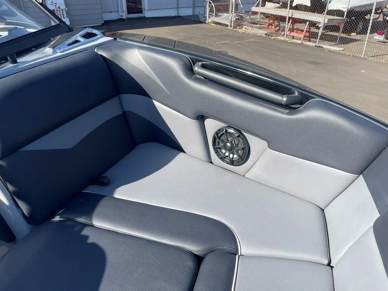 Slide: The Image of 2025 Moomba Mondo boat interior with black and gray seating and built-in speaker. - 25