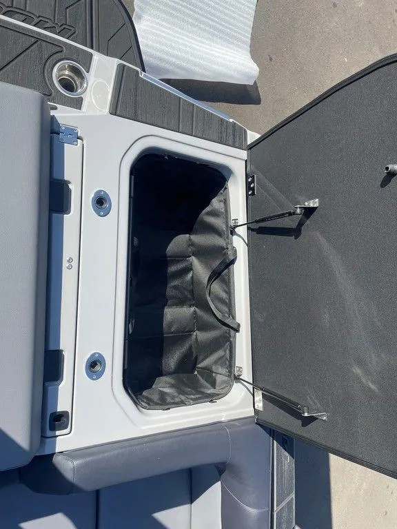 Slide: The Image of 2025 Moomba Mondo boat storage compartment with open lid and black interior. - 31