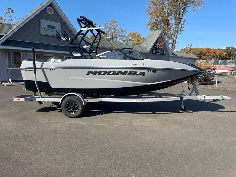 Slide: The Image of 2025 Moomba Mondo boat on trailer, parked outside dealership, clear sky. - 7