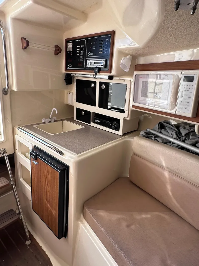 Slide: The Image of 2004 Scout 280 Abaco boat interior with kitchenette, microwave, and seating area. - 15