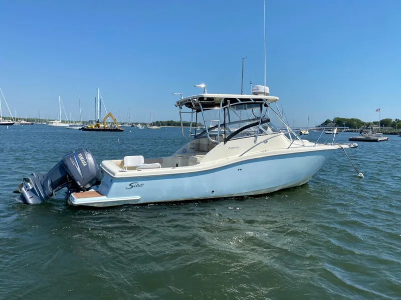 Slide: The Image of 2004 Scout 280 Abaco boat on water, clear sky, marina background. - 2