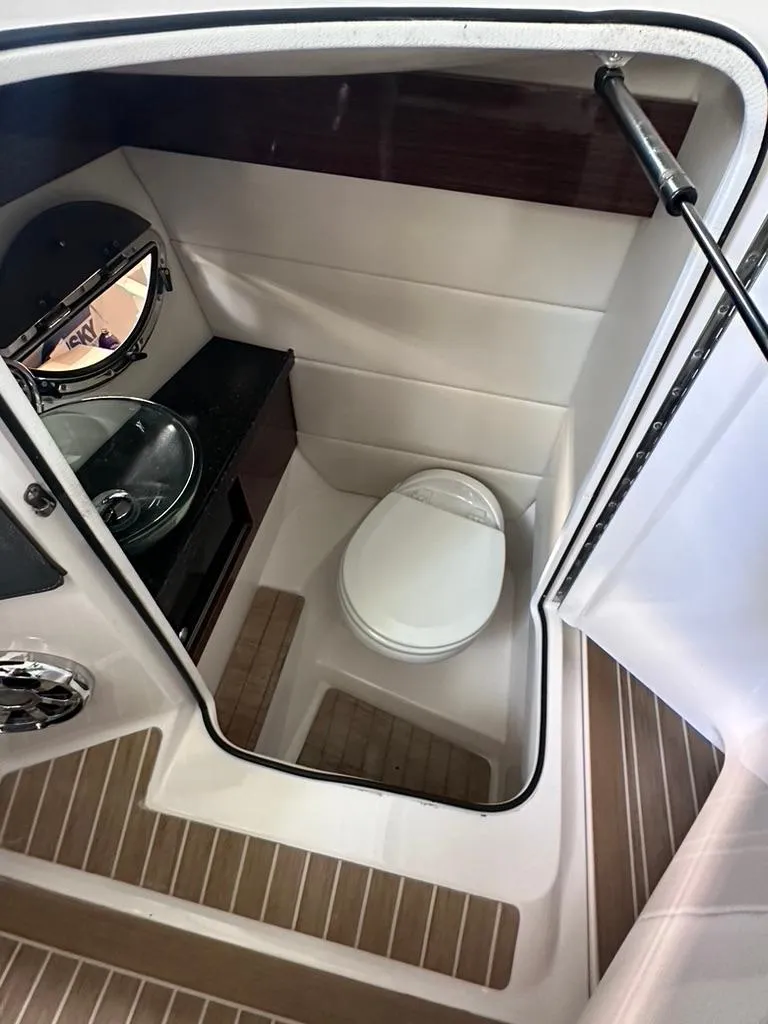 Slide: The Image of 2015 Regal 2800 Bowrider boat bathroom with toilet and sink. - 14