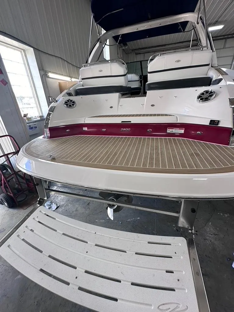 Slide: The Image of 2015 Regal 2800 Bowrider boat in a garage, rear view with swim platform. - 2