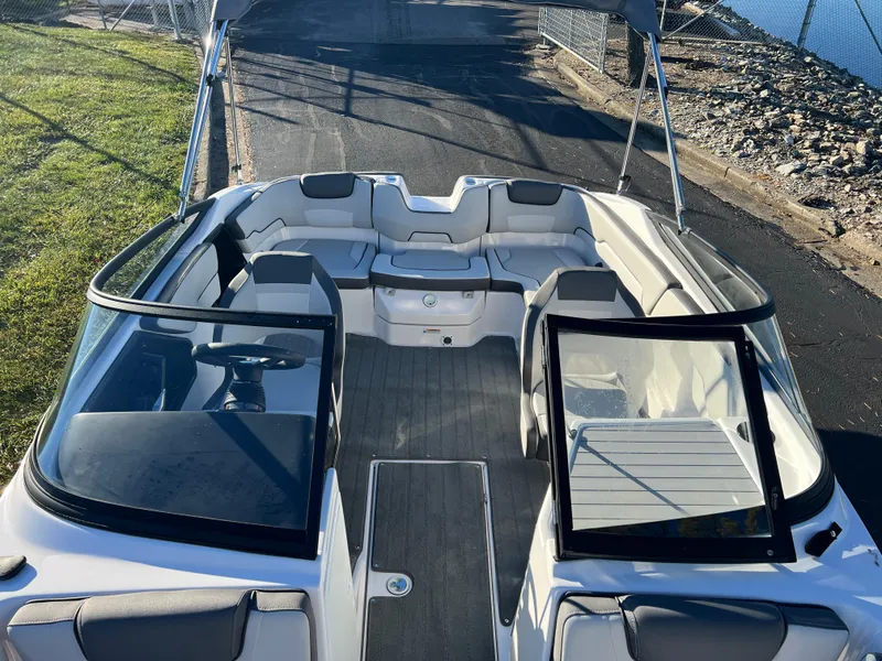 Slide: The Image of 2025 Yamaha Boats SX190 interior, sleek design, spacious seating, modern dashboard, docked by water. - 17