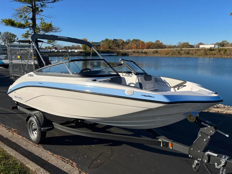 Slide: The Image of 2025 Yamaha Boats SX190 on trailer by a serene lake. - 3