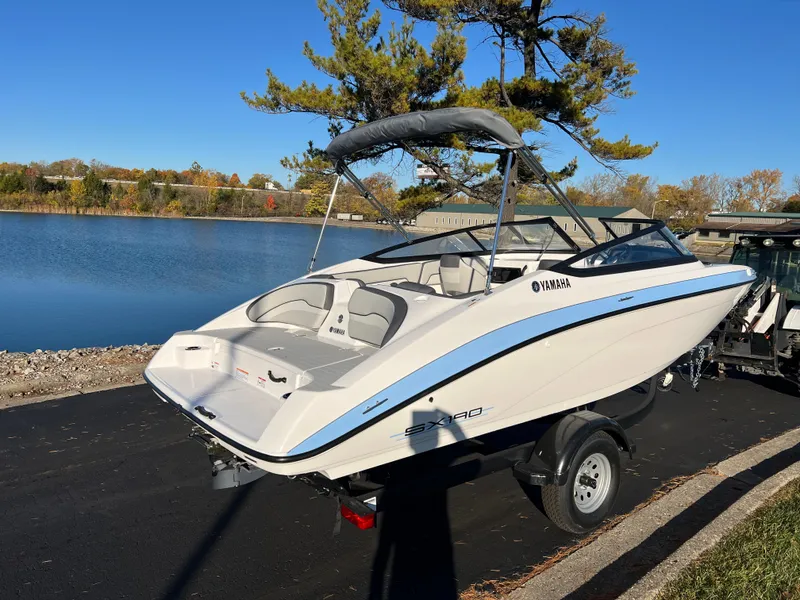Slide: The Image of 2025 Yamaha Boats SX190 by a serene lake under clear blue skies. - 5