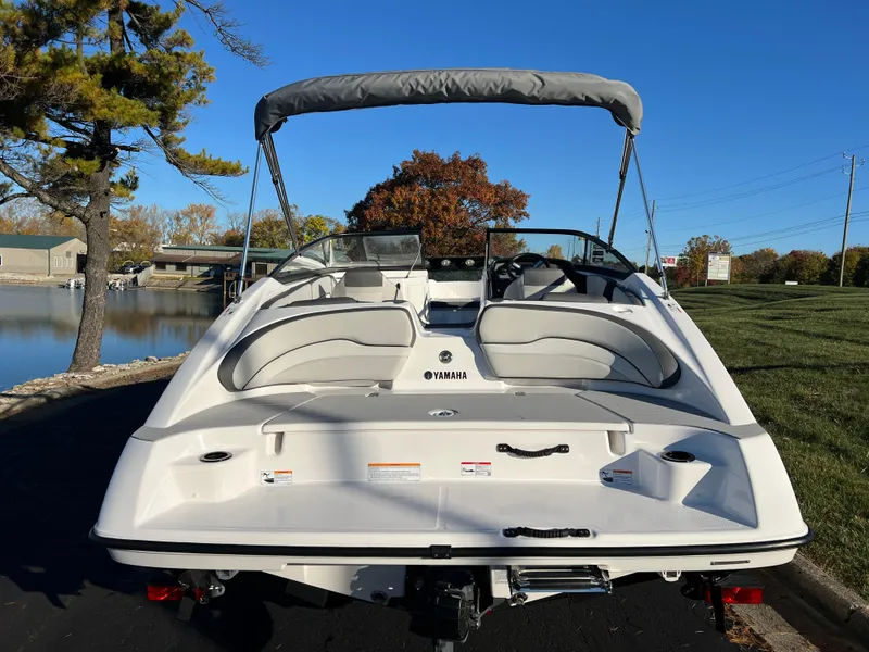 Slide: The Image of 2025 Yamaha Boats SX190, white, docked near a serene lake with trees in the background. - 6