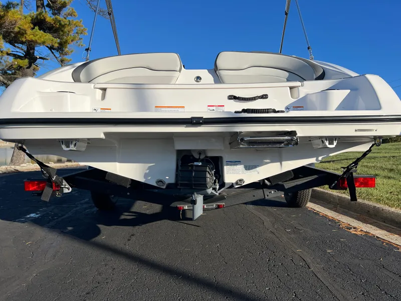 Slide: The Image of 2025 Yamaha Boats SX190 rear view on trailer, parked on asphalt. - 7
