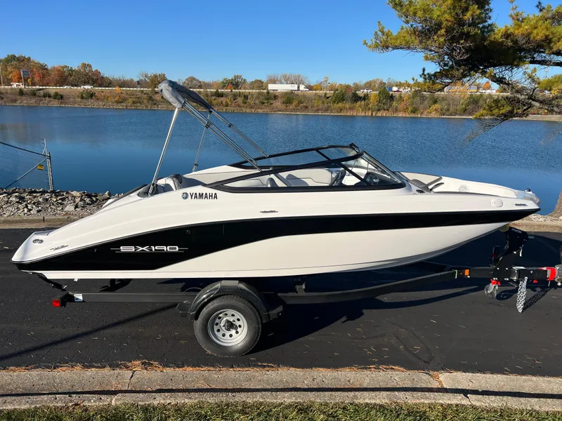 Slide: The Image of 2025 Yamaha Boats SX190 on trailer by a scenic lake. - 4