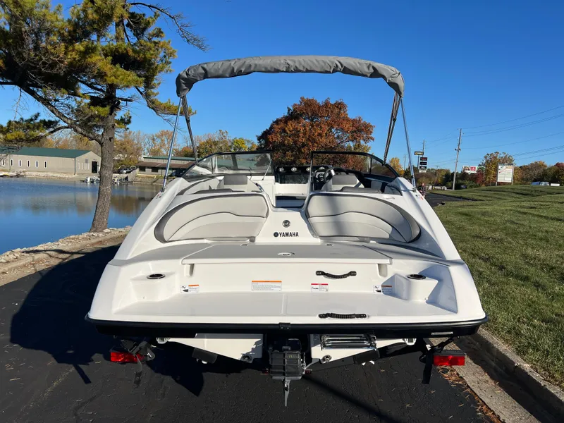 Slide: The Image of 2025 Yamaha Boats SX190, sleek design, parked near a serene lake under clear blue skies. - 6