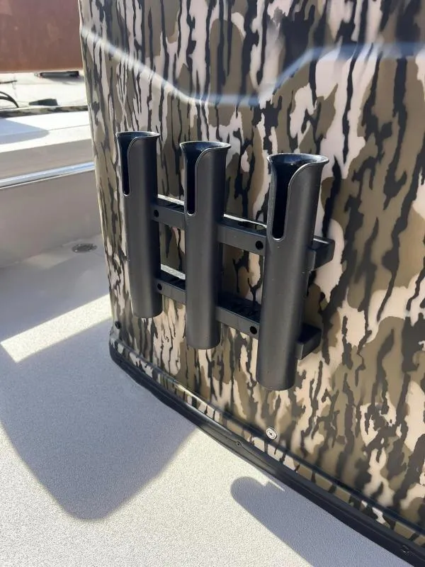 Slide: The Image of Avid 18 Center Console 2025 boat with camouflage design and rod holders. - 10