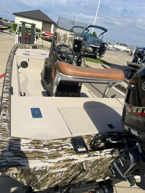 Slide: The Image of 2025 Avid 18 Center Console boat with camouflage design and brown seating. - 15