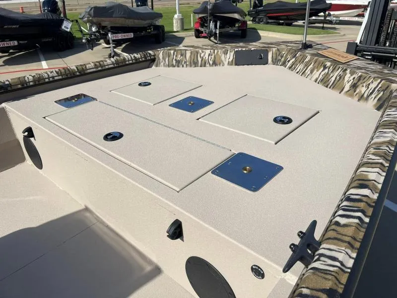 Slide: The Image of 2025 Avid 18 Center Console boat deck with storage compartments and camo trim. - 8