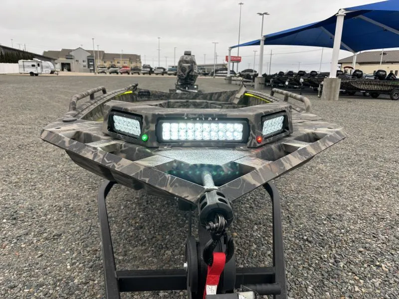 Slide: The Image of 2024 Havoc Boats 1653 MSTC with LED lights, displayed outdoors on gravel. - 2