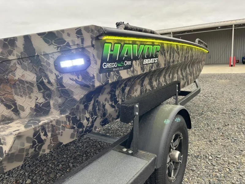 Slide: The Image of 2024 Havoc Boats 1653 MSTC with camo design on trailer, featuring LED lights. - 4