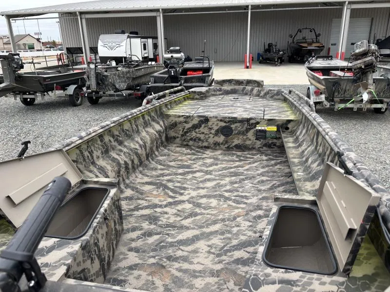 Slide: The Image of 2024 Havoc Boats 1653 MSTC with camouflage interior, parked outdoors near other boats. - 9