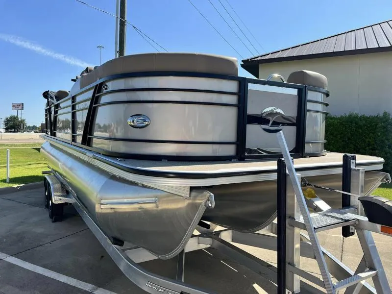Slide: The Image of 2024 Veranda VTX25RC pontoon boat on trailer, parked outdoors under clear sky. - 1