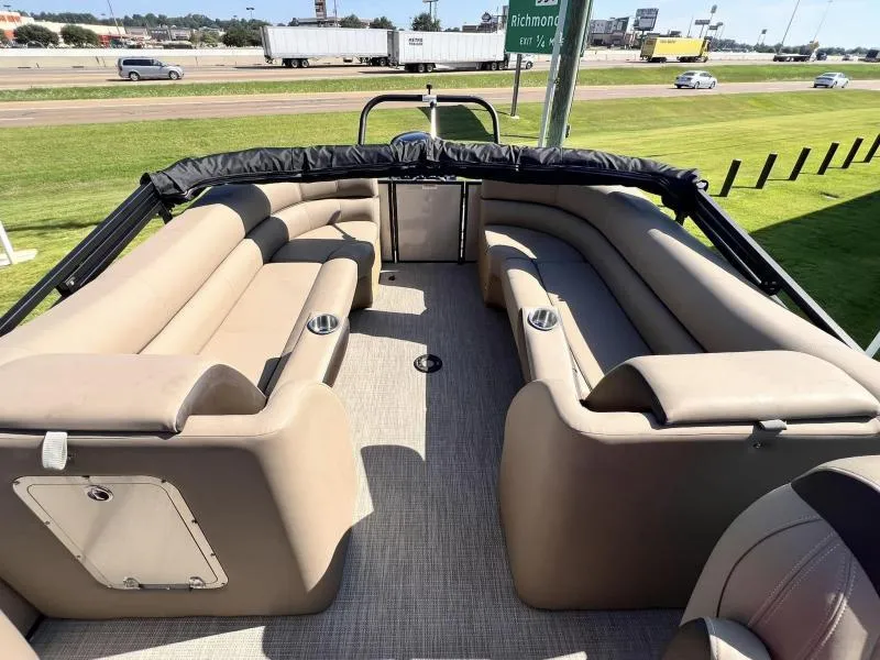 Slide: The Image of 2024 Veranda VTX25RC pontoon boat interior with beige seating and cup holders. - 11