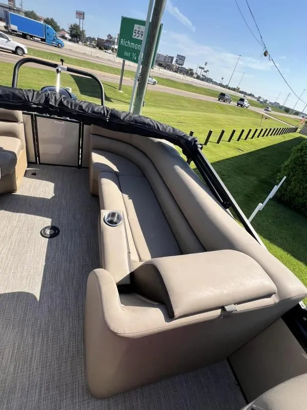 Slide: The Image of 2024 Veranda VTX25RC pontoon boat interior with beige seating and cup holders. - 12