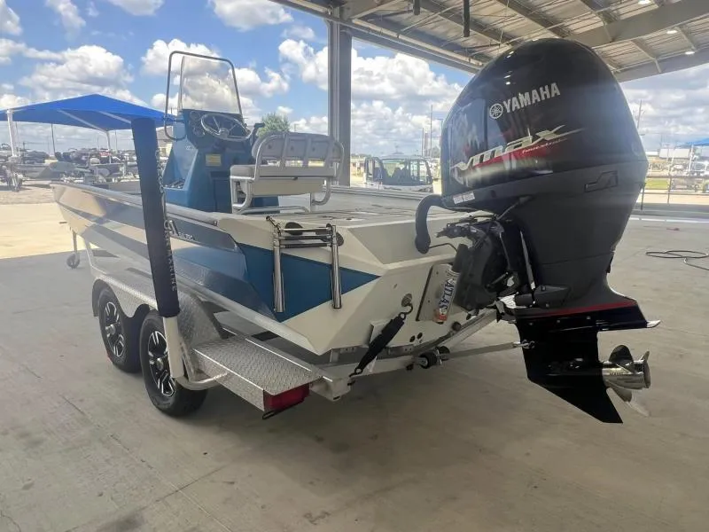 Slide: The Image of 2023 Excel Boats 220 Bay Pro with Yamaha outboard motor in a covered area. - 4
