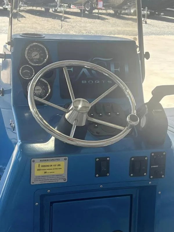 Slide: The Image of 2023 Excel Boats 220 Bay Pro dashboard with steering wheel and gauges. - 6
