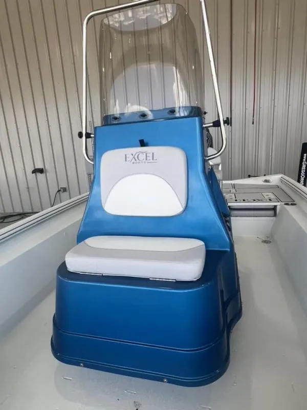 Slide: The Image of 2023 Excel Boats 220 Bay Pro interior with blue console and seating. - 9