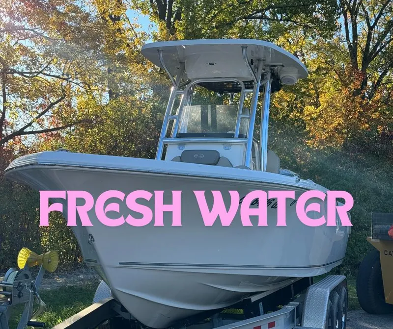 Slide: The Image of 2022 Key West 239 FS boat on trailer, surrounded by autumn trees. - 0