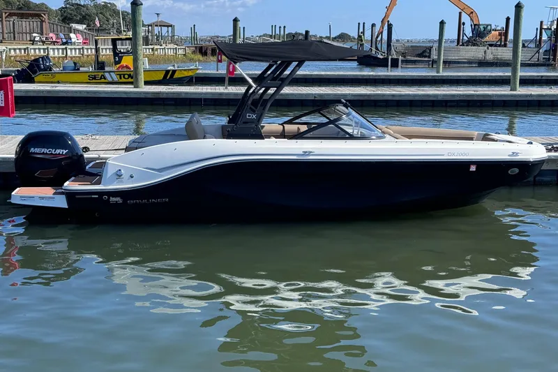 The Image of 2023 Bayliner DX2000 boat docked, featuring sleek design and Mercury outboard motor. - 0