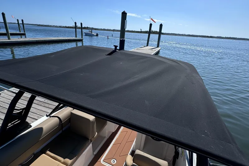 Slide: The Image of 2023 Bayliner DX2000 boat with canopy at dockside, sunny day. - 14