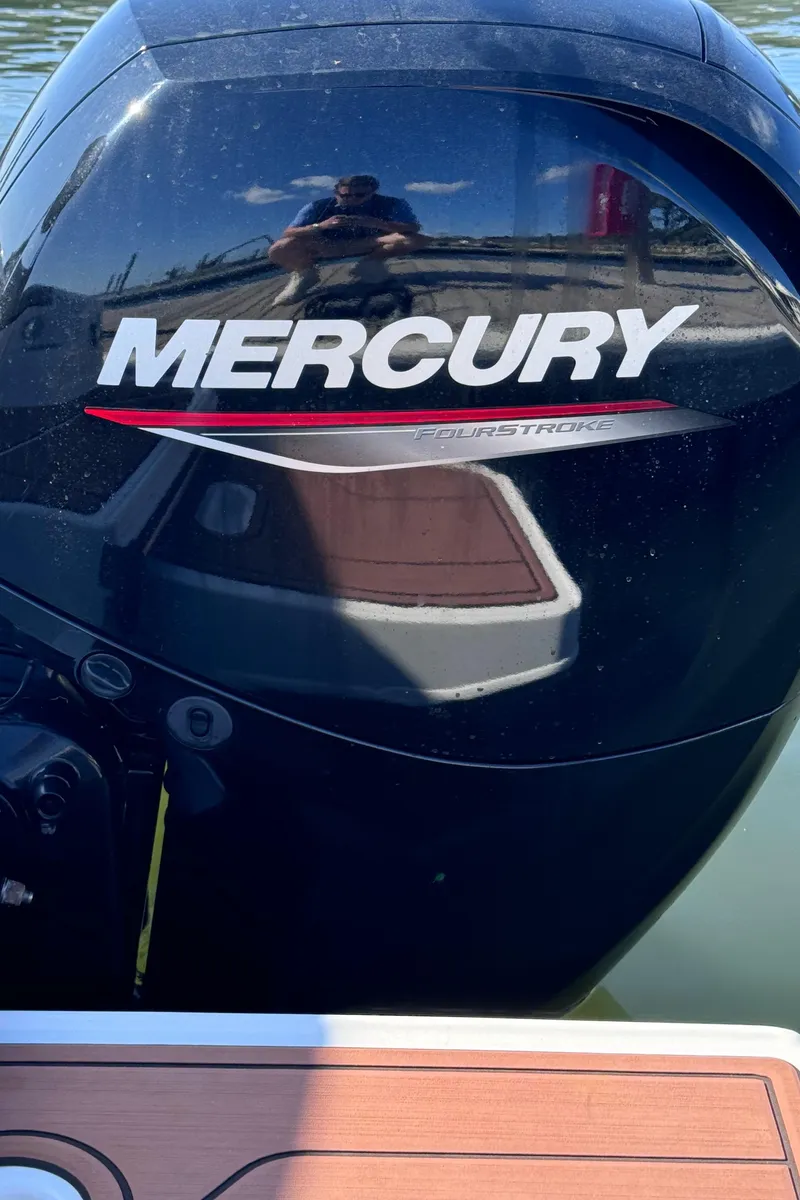 Slide: The Image of 2023 Bayliner DX2000 with Mercury outboard engine on water. - 19