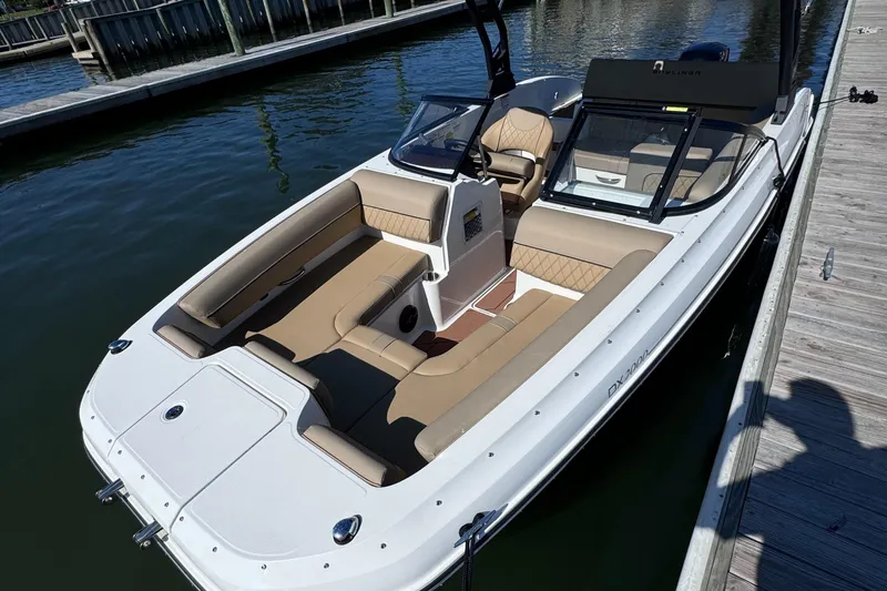 Slide: The Image of 2023 Bayliner DX2000 boat docked, featuring spacious seating and sleek design. - 2