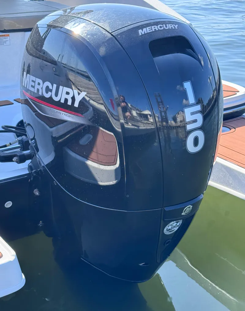 Slide: The Image of Mercury 150 outboard motor on 2023 Bayliner DX2000 boat, docked on calm water. - 20