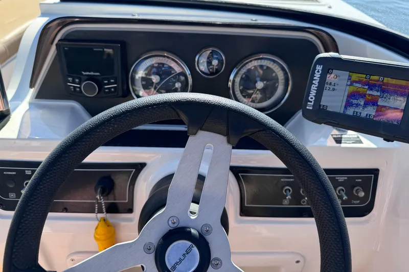 Slide: The Image of 2023 Bayliner DX2000 boat dashboard with steering wheel and navigation system. - 8