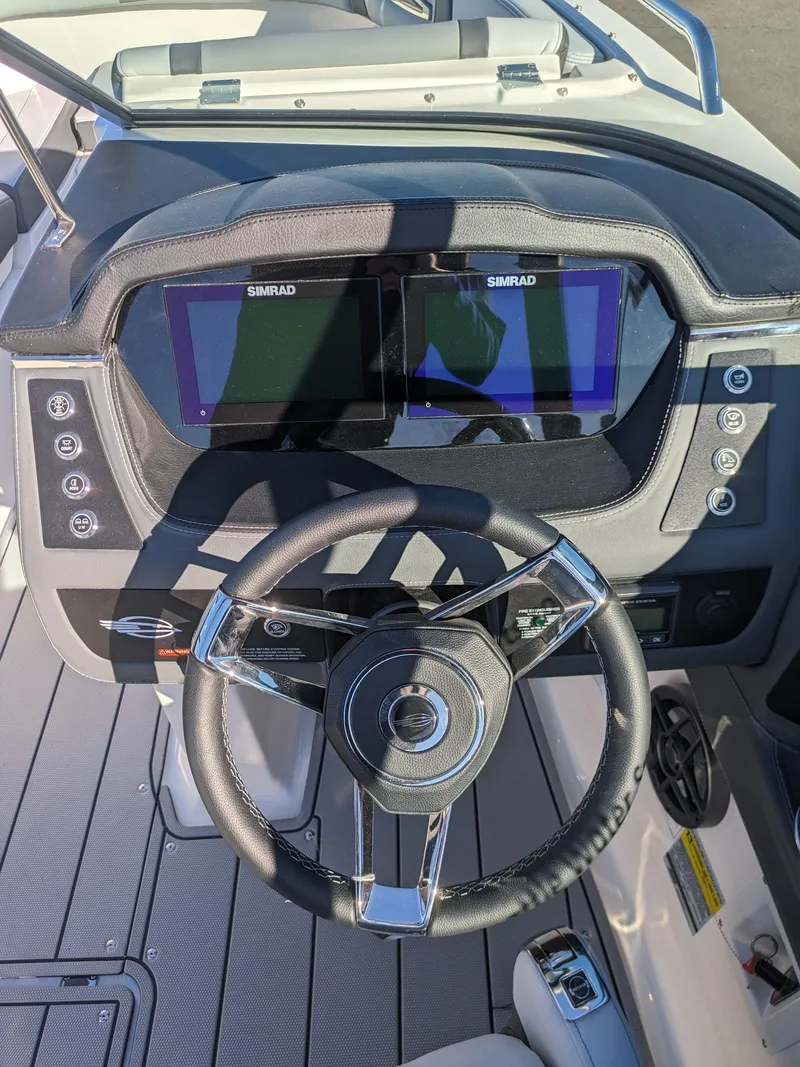 Slide: The Image of 2025 Chaparral 247 SSX dashboard with dual Simrad displays and modern steering wheel. - 16