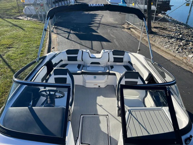 Slide: The Image of 2025 Yamaha Boats SX195 interior with seating and steering wheel, docked near water. - 15