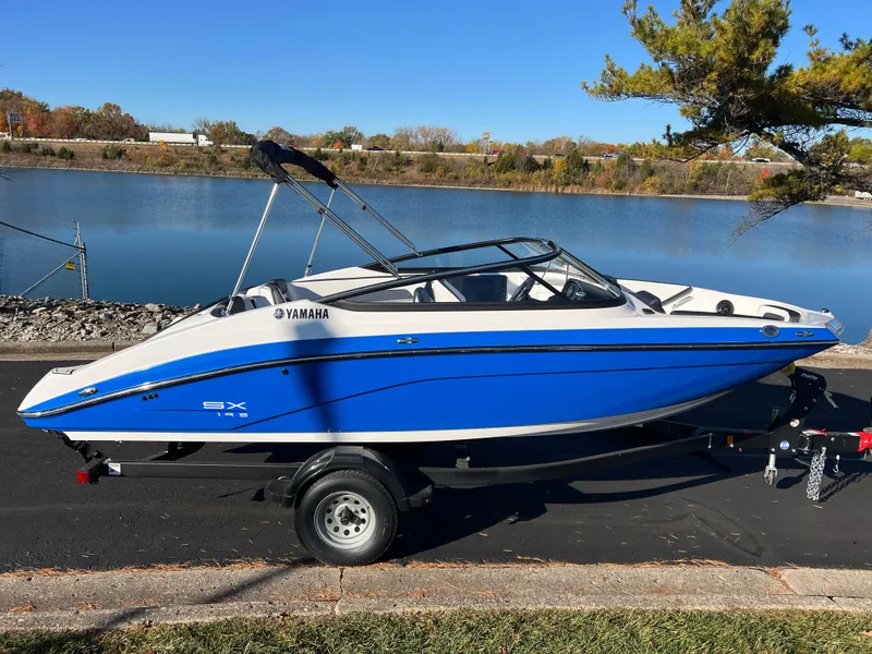 Slide: The Image of 2025 Yamaha SX195 boat in blue, parked by a serene lake. - 4