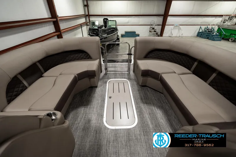Slide: The Image of 2025 Bennington 25 LTFB boat interior with plush seating in a showroom. - 15
