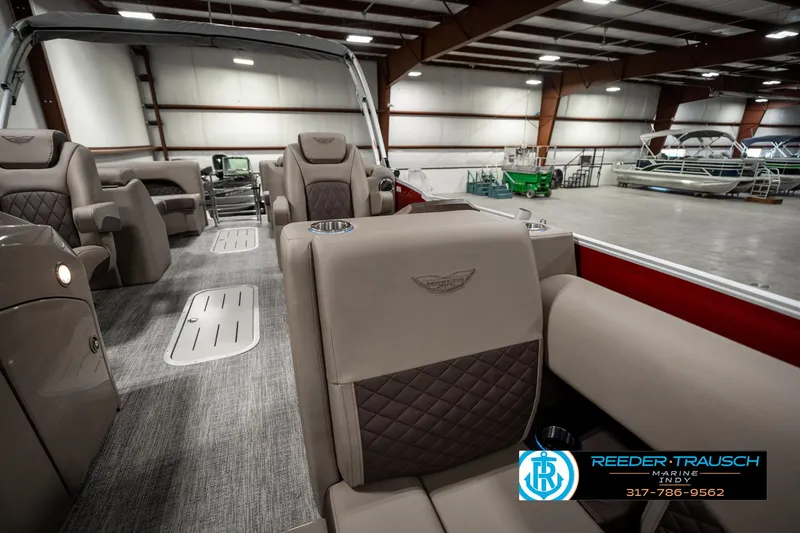 Slide: The Image of 2025 Bennington 25 LTFB pontoon boat interior with luxurious seating in a spacious warehouse. - 20