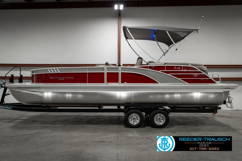 Slide: The Image of 2025 Bennington 25 LTFB pontoon boat with red and silver design on trailer. - 5