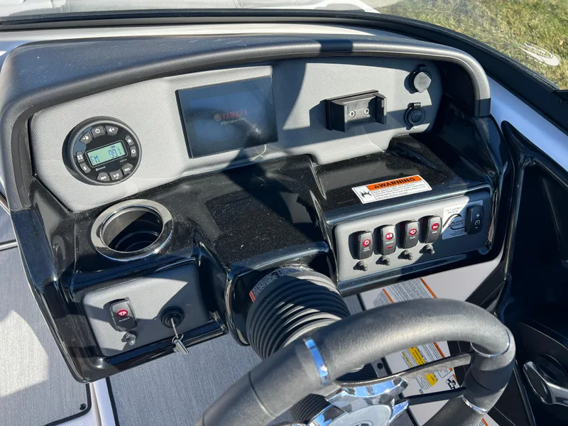 Slide: The Image of 2025 Yamaha SX195 boat dashboard with controls and steering wheel. - 13