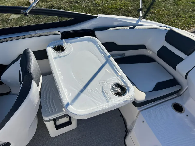 Slide: The Image of 2025 Yamaha Boats SX195 interior with seating and table, featuring cup holders. - 22