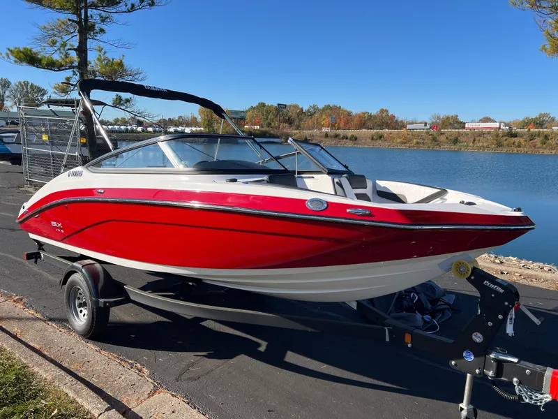 Slide: The Image of 2025 Yamaha SX195 boat, red and white, parked by a lake. - 3