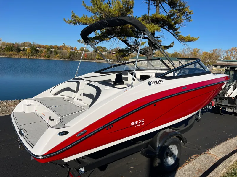 Slide: The Image of 2025 Yamaha Boats SX195, red and white, docked by a serene lake. - 5