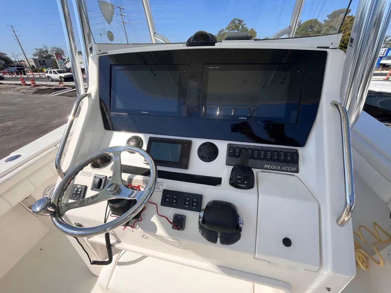 Slide: The Image of 2018 Regulator 34 boat dashboard with steering wheel and electronic displays. - 10